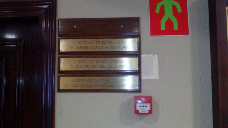 Placa de latón grabada en bajo relieve y patina de tintasobre peana o metopa de madera. Universidad de Sevilla.
