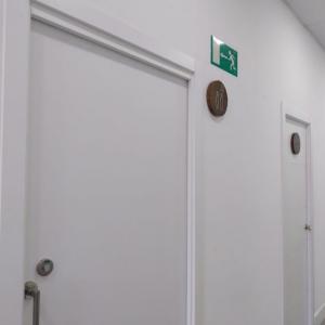 R&oacute;tulos en base de madera lacada y con pictograma en acero inoxidable. Cl&iacute;nica 28 en Sevilla.