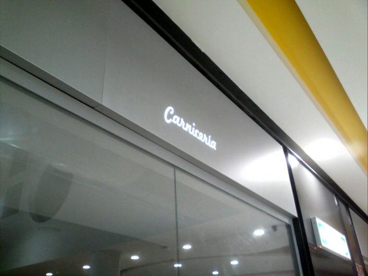 Letras corp&oacute;reas cajeadas y fresadas e iluminadas, sobre frente de dib&oacute;n. Galer&iacute;a comercial de Alcampo Sevilla.