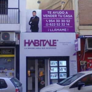 Forrado de fachada con composite lacadao y Rotulación de vinilos y letras corpóreas. Inmobiliaria Habitale Sevilla.