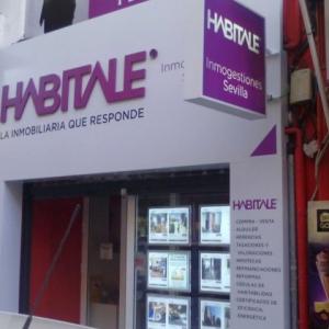 Forrado de fachada con composite lacadao y Rotulación de vinilos y letras corpóreas. Inmobiliaria Habitale Sevilla.