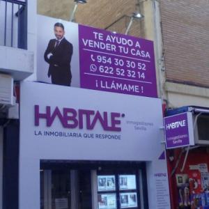 Forrado de fachada con composite lacadao y Rotulación de vinilos y letras corpóreas. Inmobiliaria Habitale Sevilla.