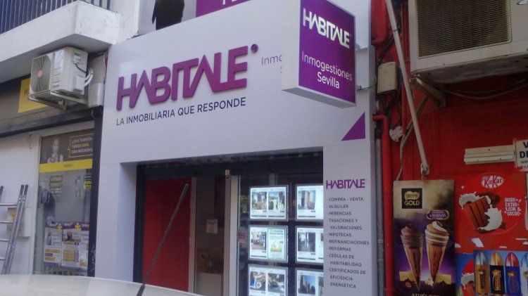 Forrado de fachada con composite lacadao y Rotulación de vinilos y letras corpóreas. Inmobiliaria Habitale Sevilla.
