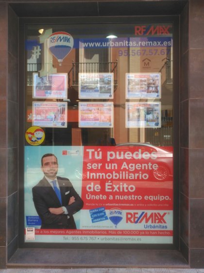 Rotulación de cristales, escaparate en vinilo incoloro con reserva en impresión digital. Remax Dos Hermanas Sevilla