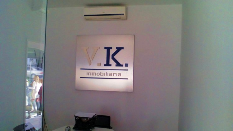 Rótulo en placa de acero inoxidable y letras en pvc. VK Inmobiliarias Sevilla.