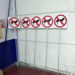 Cartel prohibición de perros con poste, para el campus de la Universidad de Sevilla en Reina Mercedes.