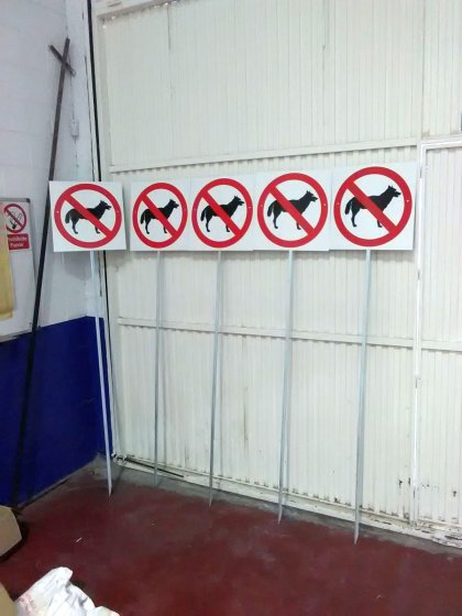 Cartel prohibición de perros con poste, para el campus de la Universidad de Sevilla en Reina Mercedes.