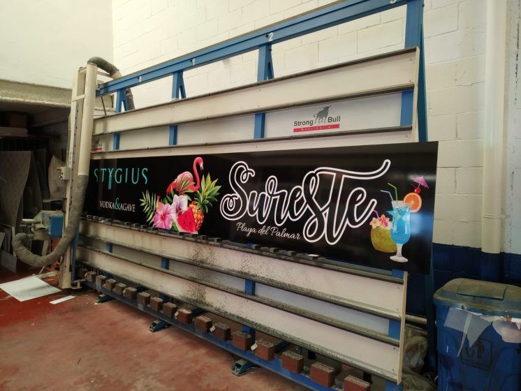 Fabricación de dibón rotulado en impresión digital laminado para decoración de SurEste en la playa de El Plamar. Trabajos para Stygius Sevilla. 