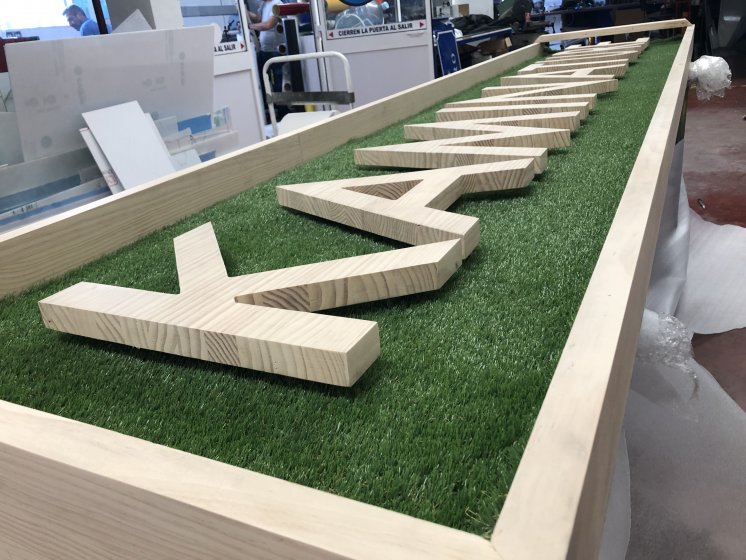 Letras corpóreas en madera natural con cesped artifical e iluminados con led para Kaminature en Sevilla.