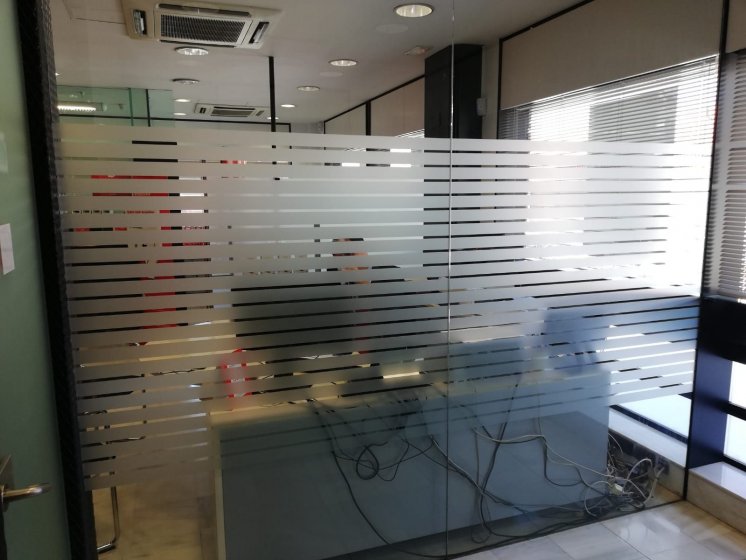 Rotulación de vinilos ácido plata para el Banco Santander en Sevilla.