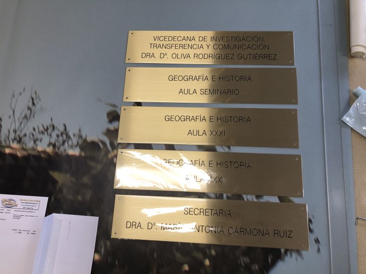 Rótulo Cartel de señalización en latón grabado en bajo relieve con tintas especiales. Rectorado de la Universidad de Sevilla.