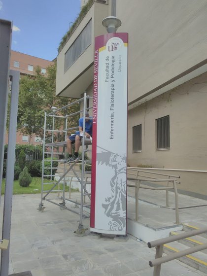 Rótulo Totém Homologado en colores corporativos para la Facultad de Enfermería, Fisioterapia y Podología de la Universidad de Sevilla.