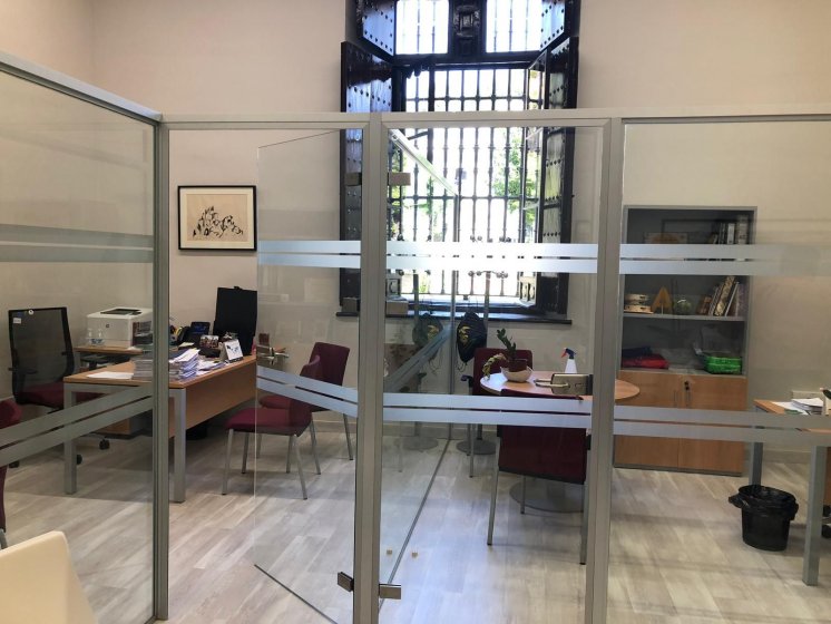 Rotulación de mamparas de oficina en vinilo ácido plata. Comunicación de la Universidad de Sevilla.