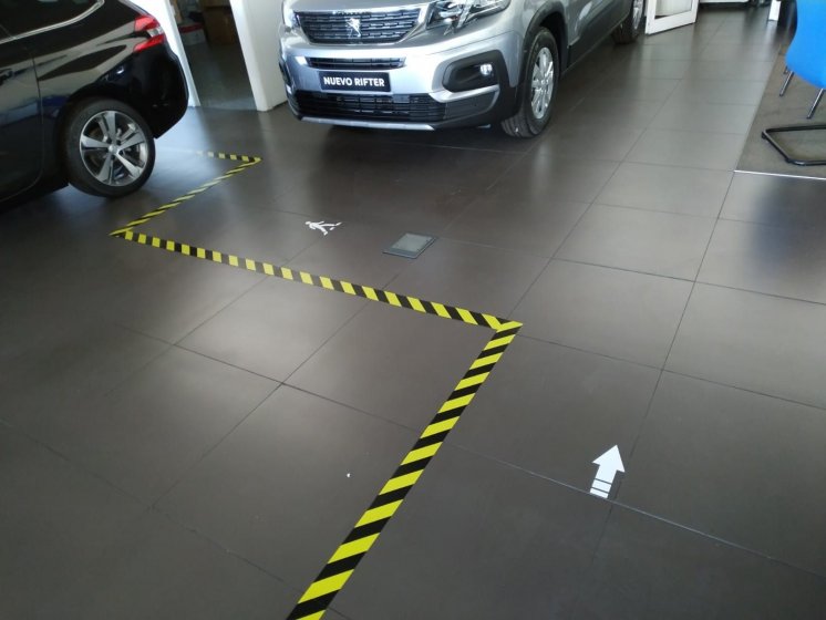 Rotulaci&oacute;n y se&ntilde;alizaci&oacute;n de suelo frente al coronavirus covid 19 en concesionarios Peugeot Automares en Sevilla.