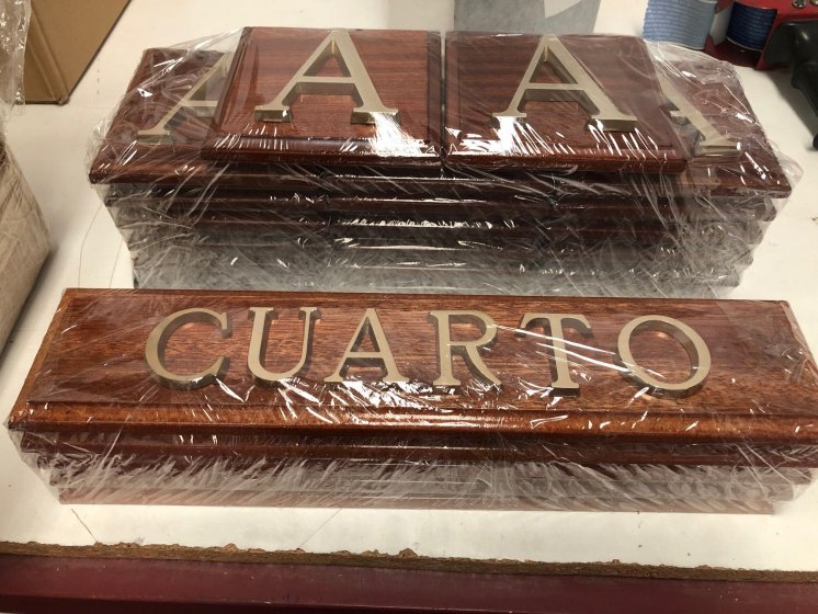 R&oacute;tulo cartel en base de madera y letras en lat&oacute;n fundido.