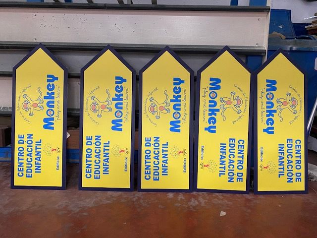 R&oacute;tulo cartel en forma de flecha indicadora, rotulada en impresi&oacute;n digital con laminado. Centro de Educaci&oacute;n Infaltil Monkey, en Dos Hermanas, Sevilla