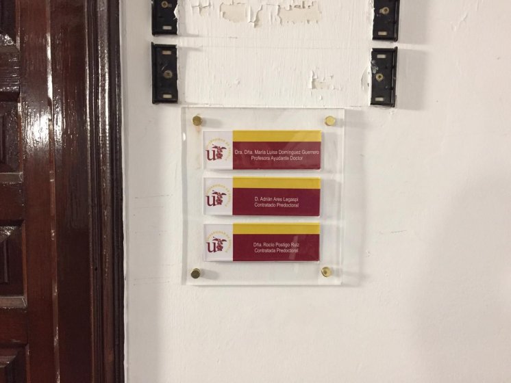 R&oacute;tulo Cartel de se&ntilde;alizaci&oacute;n en base de metaxcrialto con carpetas resposicionable. Facultad de Geograf&iacute;a e Historia de la Universidad de Sevilla.