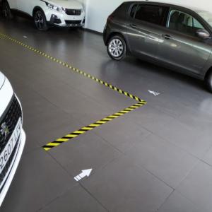 Rotulación y señalización de suelo frente al coronavirus covid 19 en concesionarios Peugeot Automares en Sevilla.