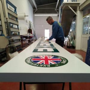 Rótulo cartel en bandeja plegada con bastidor y rotulado con vinilos garantizados para exterior. Sevilla.