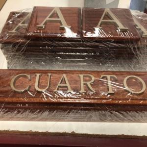 Rótulo cartel en base de madera y letras en latón fundido.