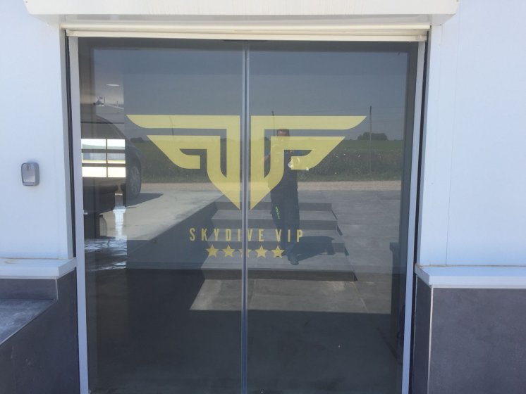 Rotulación de cristal en vinilo de corte dorado para Skydive Vip en aeródromo la Juliana Sevilla.