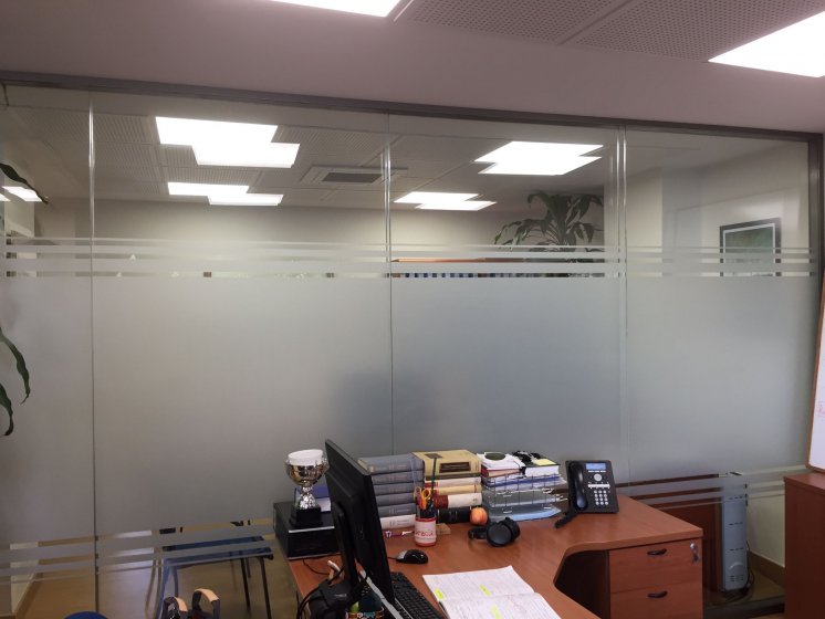 Rotulación de mamparas de separación de cristal con vinilos imitación ácido plata o chorro de arena. Para Construcciones Falusa Sevilla.