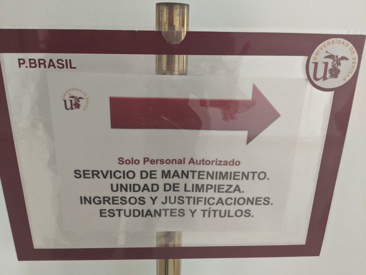 Rótulo indicador con carpeta de metacrilato para documento reposicionable Universidad de Sevilla.