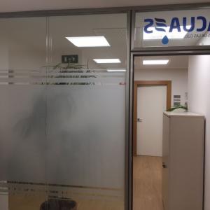 Rotulación de mamparas de separación de cristal con vinilos imitación ácido plata o chorro de arena. Para Construcciones Falusa Sevilla.
