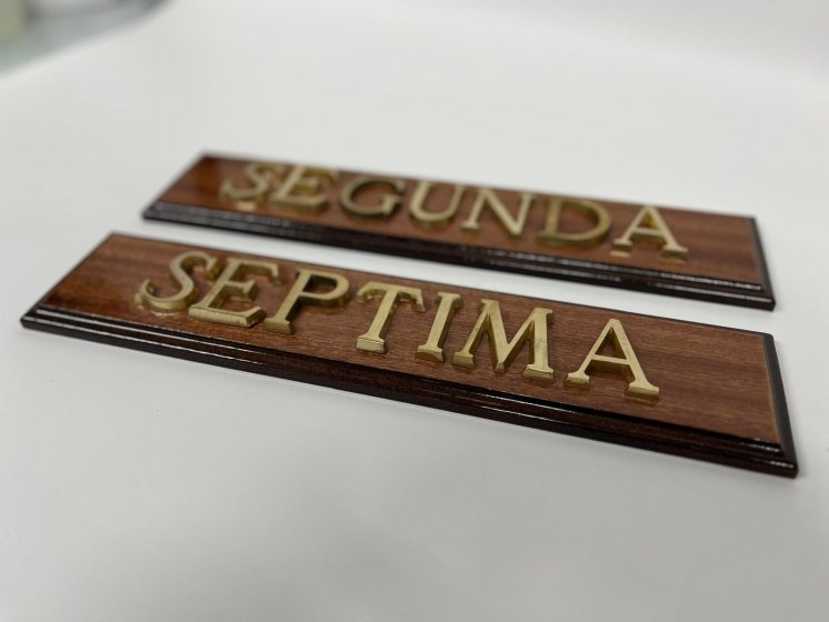 Rótulo señalizador con texto en latón fundido con base de madera.