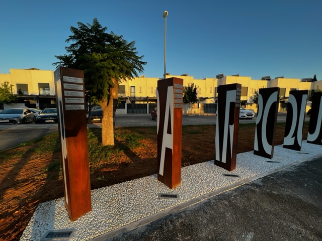 T&oacute;tem en acero cort&eacute;n con texto en aluminio lacado y carteles en acero inoxidable grabados en bajo relieve y patina de tinta negra, para el Ayuntamiento de Dos Hermanas, Sevilla.