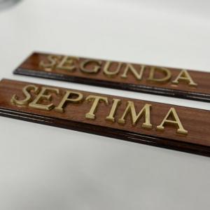 Rótulo señalizador con texto en latón fundido con base de madera.